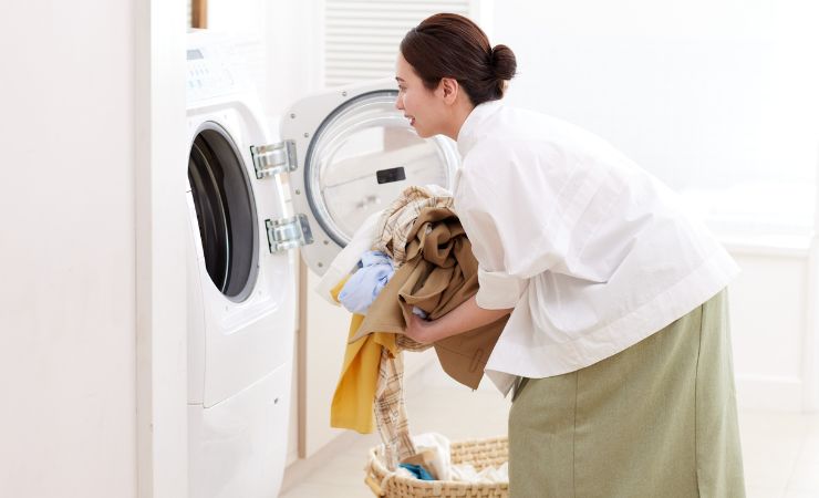 femme avec du linge dans la machine à laver