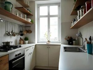 Petite cuisine urbaine lumineuse avec ustensiles suspendus et plan de travail dégagé