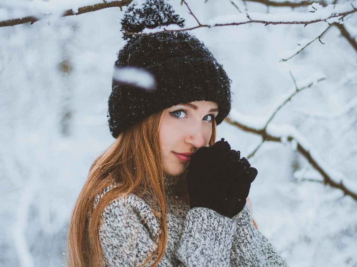 donna con cappello di lana, paesaggio innevato