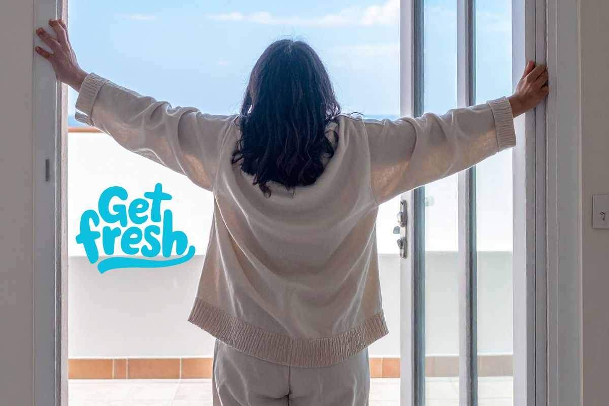 Femme ouvrant le balcon et profitant de l’air frais